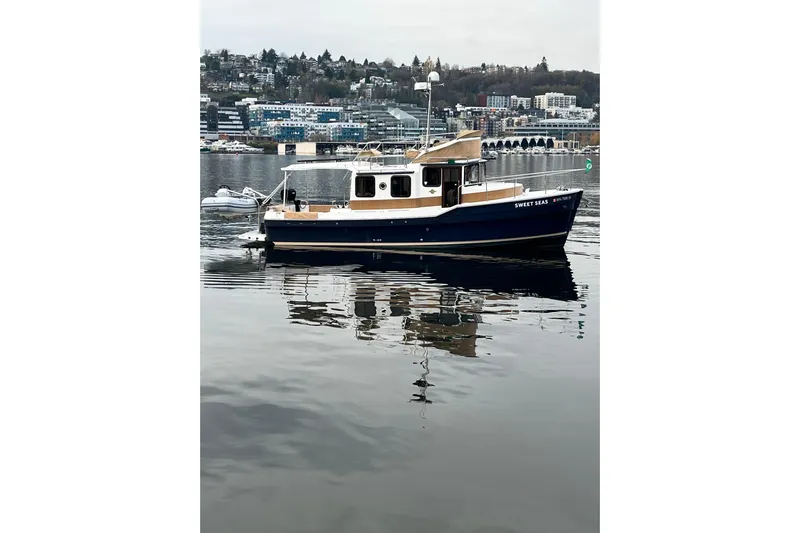  Yacht Photos Pics 2017 Ranger Tugs R-31 CB boat on calm water with cityscape background.