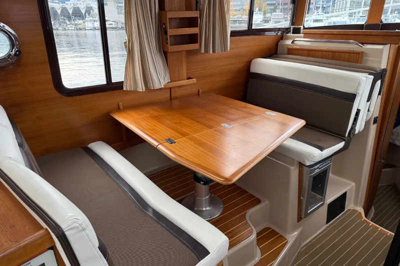  Yacht Photos Pics Interior of 2017 Ranger Tugs R-31 CB with wooden table and cushioned seating.