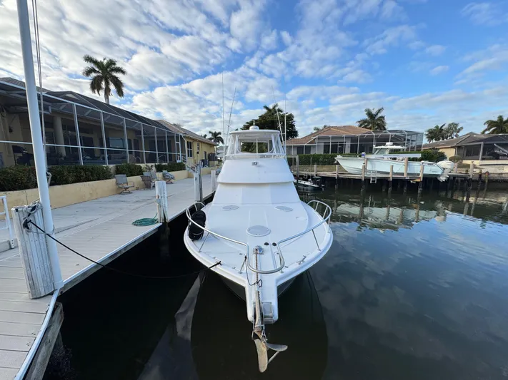  Yacht Photos Pics 2002 Riviera 40 Convertible yacht docked in a serene marina setting.