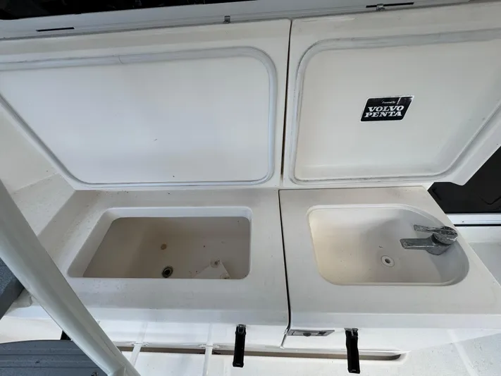  Yacht Photos Pics Riviera 40 Convertible 2002 boat sink and storage area with Volvo Penta label.