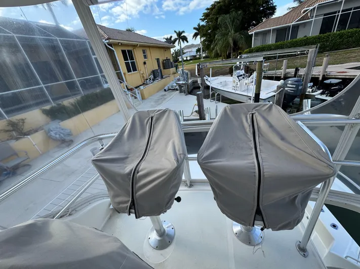  Yacht Photos Pics Covered seats on a 2002 Riviera 40 Convertible boat docked near waterfront homes.