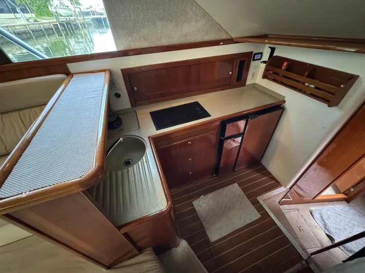  Yacht Photos Pics Interior of 2002 Riviera 40 Convertible yacht with compact kitchen and wooden cabinetry.