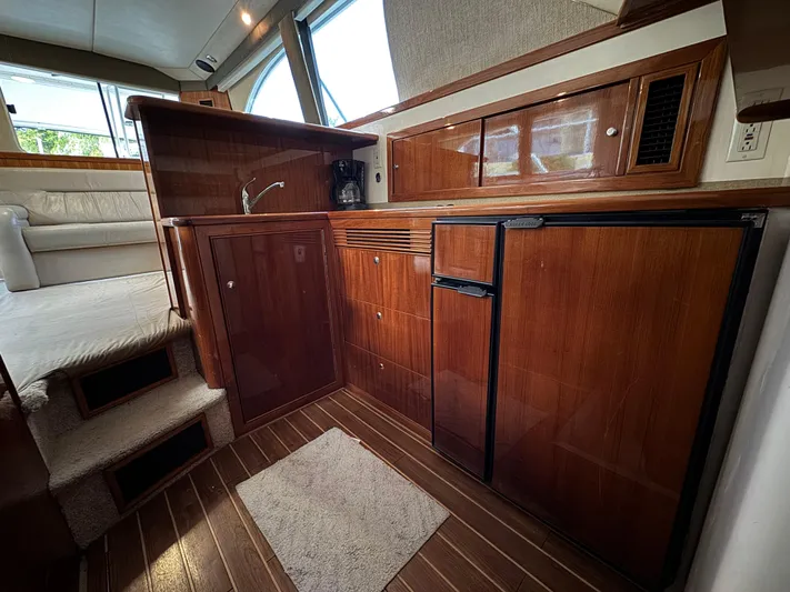  Yacht Photos Pics Luxurious 2002 Riviera 40 Convertible yacht interior with wood cabinetry and compact kitchen.