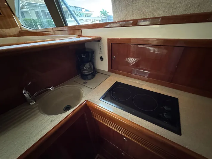  Yacht Photos Pics 2002 Riviera 40 Convertible yacht kitchen with sink, stovetop, and coffee maker.