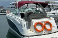 2009 Chaparral 290 Signature boat docked with lifebuoys, under a cloudy sky.