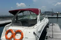 2009 Chaparral 290 Signature boat docked with red canopy and life rings.