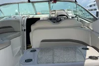 2009 Chaparral 290 Signature boat interior with seating and table, under a maroon canopy.