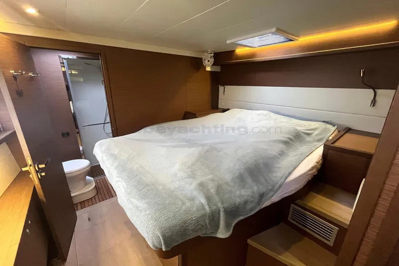  Yacht Photos Pics Luxurious cabin interior of 2019 Lagoon 52 S yacht with cozy bed and ensuite bathroom.