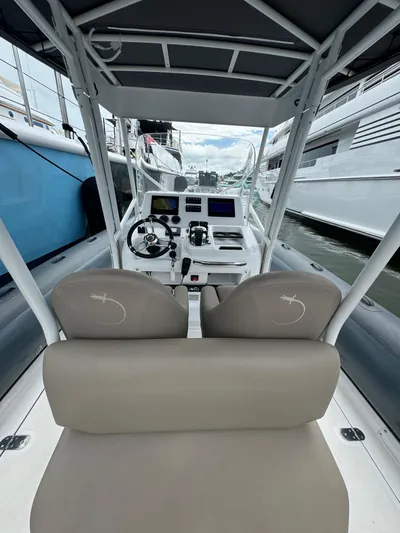  Yacht Photos Pics Interior view of Iguana X100 boat cockpit with modern controls and seating, docked at marina.