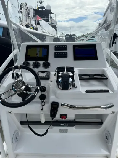  Yacht Photos Pics Boat control panel with steering wheel, digital displays, and navigation equipment on Iguana X100, 2021 model.