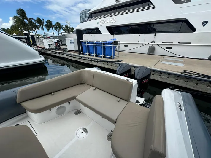  Yacht Photos Pics Luxury yacht docked with comfortable seating area, palm trees, and clear sky in the background.