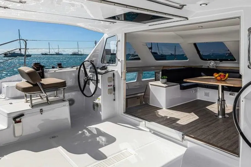  Yacht Photos Pics 2022 Seawind 1160 Lite catamaran interior with helm, seating, and ocean view.