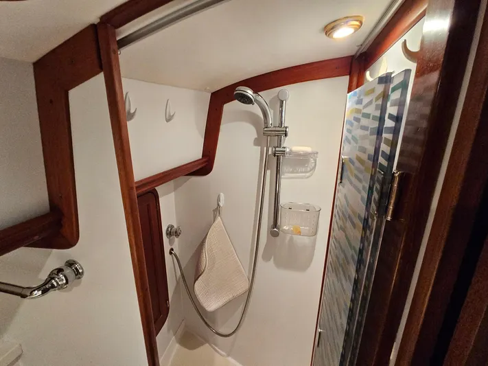 Lady One Yacht Photos Pics 2003 Legacy 40 Hardtop Express boat shower with wooden accents and modern fixtures.
