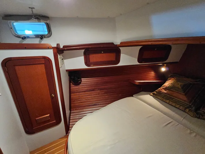 Lady One Yacht Photos Pics 2003 Legacy 40 Hardtop Express cabin with wood paneling and cozy bed.