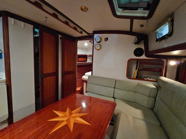 Lady One Yacht Photos Pics Interior of 2003 Legacy 40 Hardtop Express yacht with wooden table and cushioned seating.