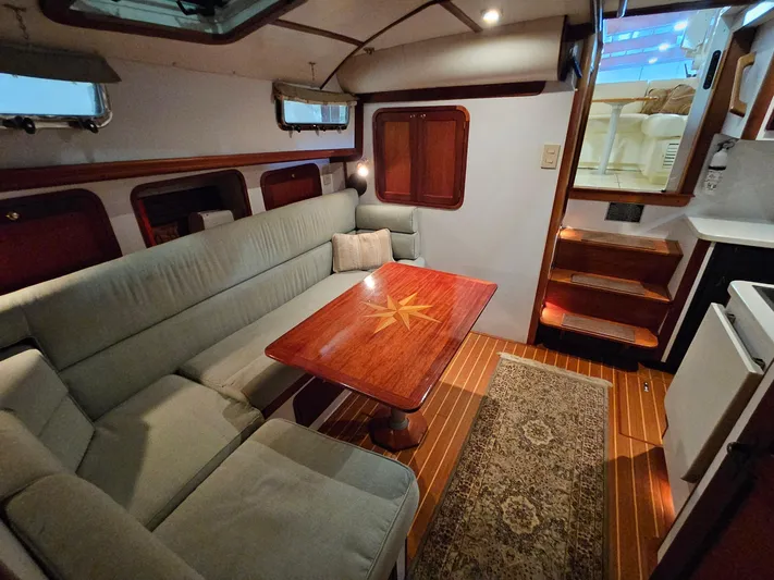 Lady One Yacht Photos Pics Interior of 2003 Legacy 40 Hardtop Express yacht with cozy seating and wooden table.