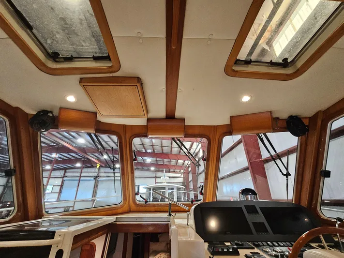 Lady One Yacht Photos Pics Interior view of 2003 Legacy 40 Hardtop Express boat cockpit with wooden accents and control panel.