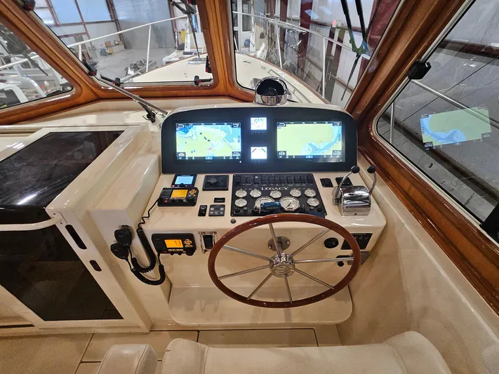 Lady One Yacht Photos Pics 2003 Legacy 40 Hardtop Express helm with navigation screens and wooden steering wheel.