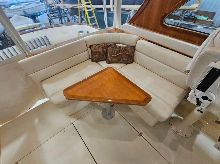 Lady One Yacht Photos Pics 2003 Legacy 40 Hardtop Express interior with cushioned seating and wooden table.
