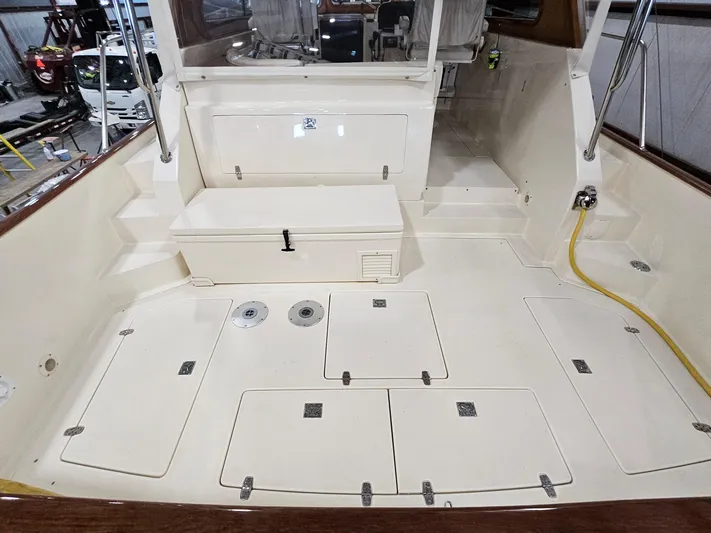 Lady One Yacht Photos Pics 2003 Legacy 40 Hardtop Express boat deck with storage compartments and seating area.