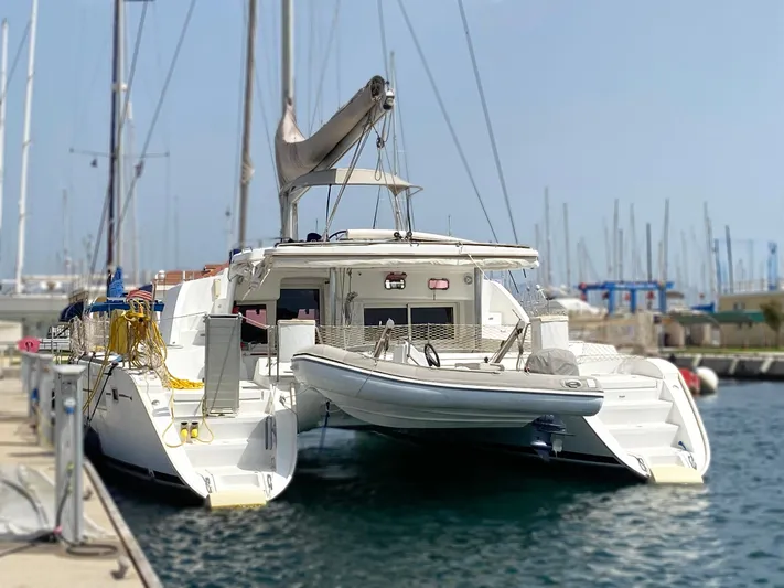  Yacht Photos Pics 2009 Lagoon 440 catamaran docked at marina, featuring spacious deck and moored dinghy.