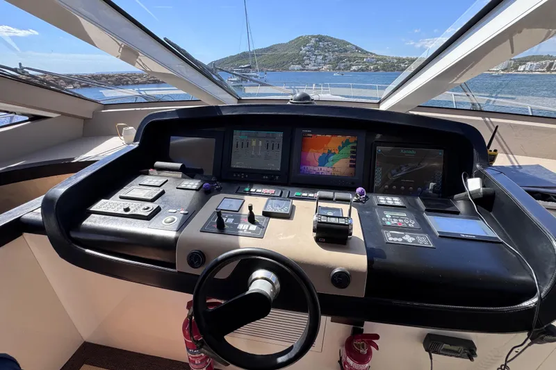  Yacht Photos Pics Cockpit of 2010 Canados 90 yacht with navigation screens and controls, overlooking scenic coastline.