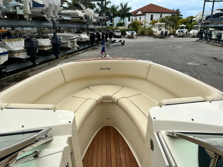  Yacht Photos Pics 2022 Chris-Craft Launch 27 boat with luxurious seating and wooden deck in a marina.