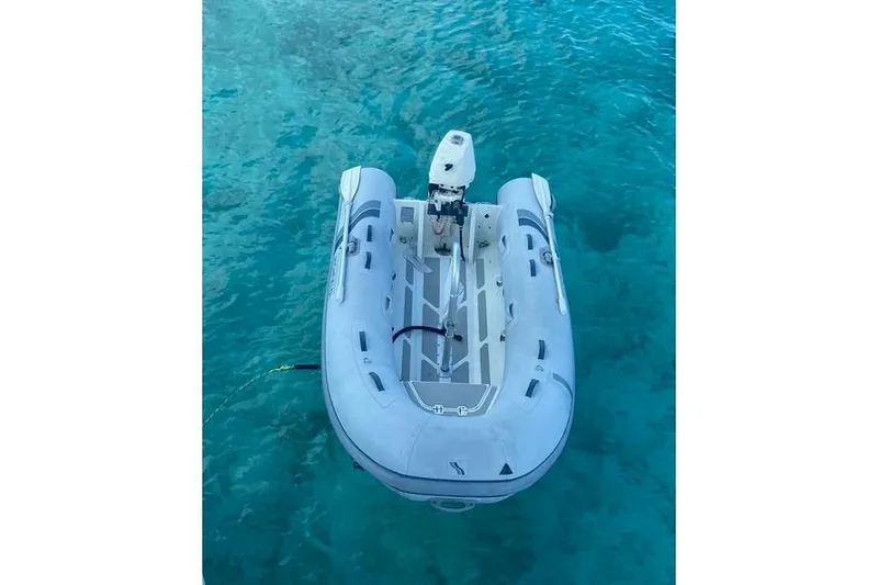 Ten Sigma (formerly Recently Korkzcrew) Yacht Photos Pics Inflatable dinghy floating on clear blue water, viewed from above.