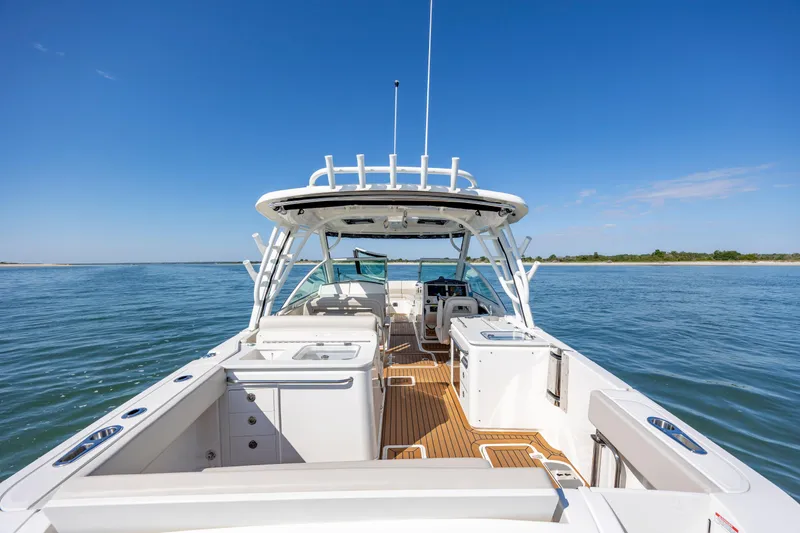  Yacht Photos Pics 2023 Boston Whaler 320 Vantage boat on calm water, showcasing spacious deck and seating.