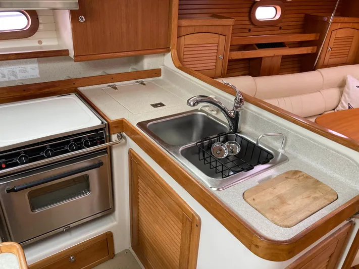  Yacht Photos Pics 2008 Catalina 470 yacht kitchen with stove, sink, and wooden cabinetry.