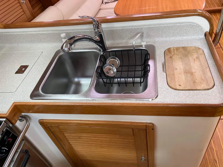 Yacht Photos Pics Modern kitchen sink area in a 2008 Catalina 470 yacht, featuring dual sinks and wooden accents.