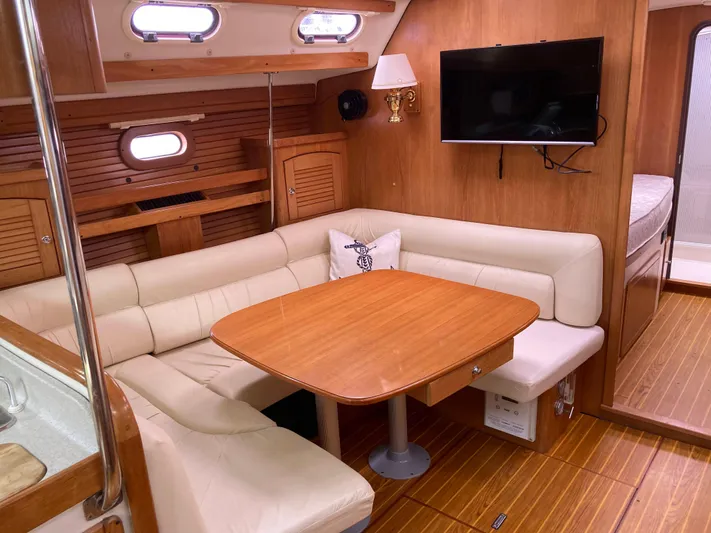  Yacht Photos Pics Luxurious 2008 Catalina 470 yacht interior with cozy seating, wooden table, and mounted TV.