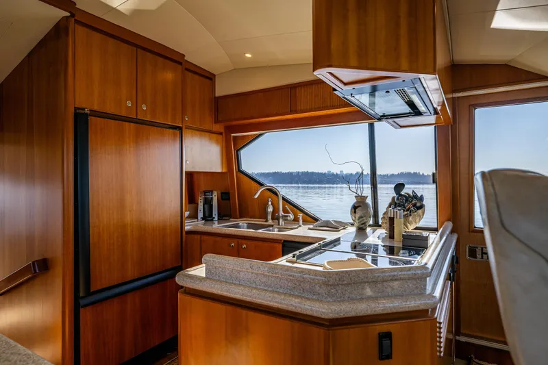 Kolokea Yacht Photos Pics Luxurious kitchen interior of 2001 West Bay 58 yacht with wood cabinetry and scenic window view.