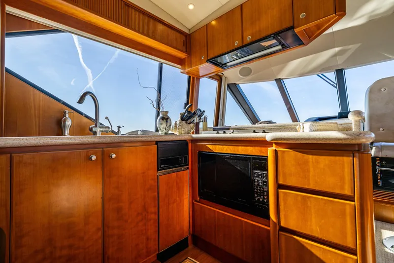 Kolokea Yacht Photos Pics Luxurious kitchen interior of 2001 West Bay 58 yacht with wooden cabinetry and modern appliances.