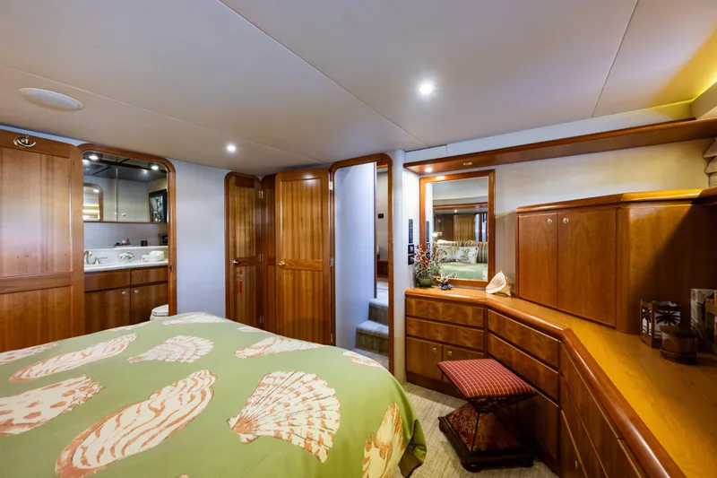 Kolokea Yacht Photos Pics Luxurious 2001 West Bay 58 yacht bedroom with elegant wood cabinetry and seashell-themed bedding.