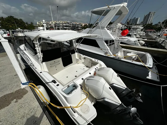  Yacht Photos Pics 2020 Boston Whaler 325 Conquest docked, featuring dual outboard engines, in a marina setting.