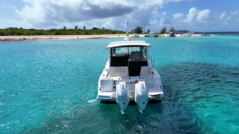  Yacht Photos Pics Boston Whaler 325 Conquest 2020 in turquoise waters near a sandy beach.