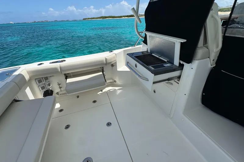  Yacht Photos Pics 2020 Boston Whaler 325 Conquest boat interior with grill, overlooking turquoise ocean waters.