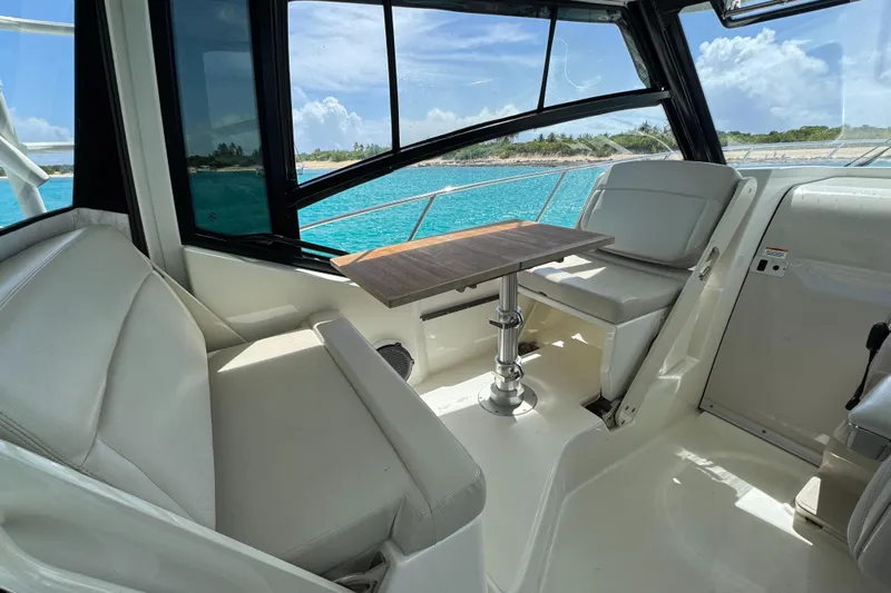  Yacht Photos Pics 2020 Boston Whaler 325 Conquest interior with seating and table, overlooking turquoise waters.