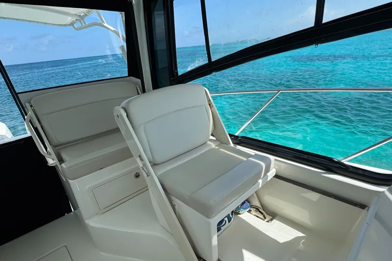  Yacht Photos Pics 2020 Boston Whaler 325 Conquest interior with ocean view, featuring white seating and windows.