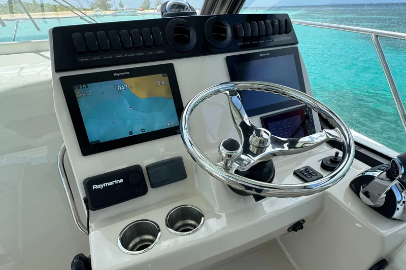  Yacht Photos Pics Boston Whaler 325 Conquest 2020 helm with navigation screens and steering wheel, ocean view.