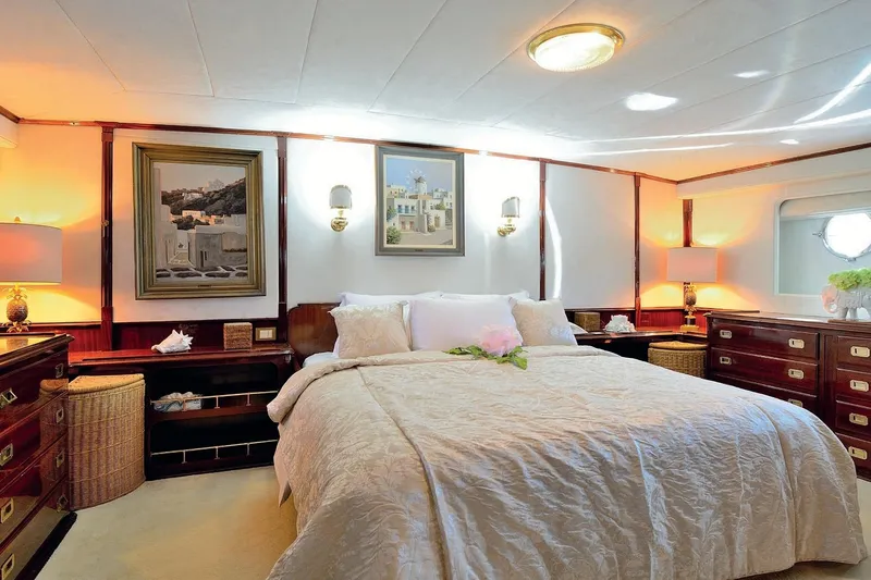 Madame Thelma Yacht Photos Pics Luxurious bedroom interior on 1975 CRN Ancona Navetta 40 yacht, featuring elegant decor and artwork.