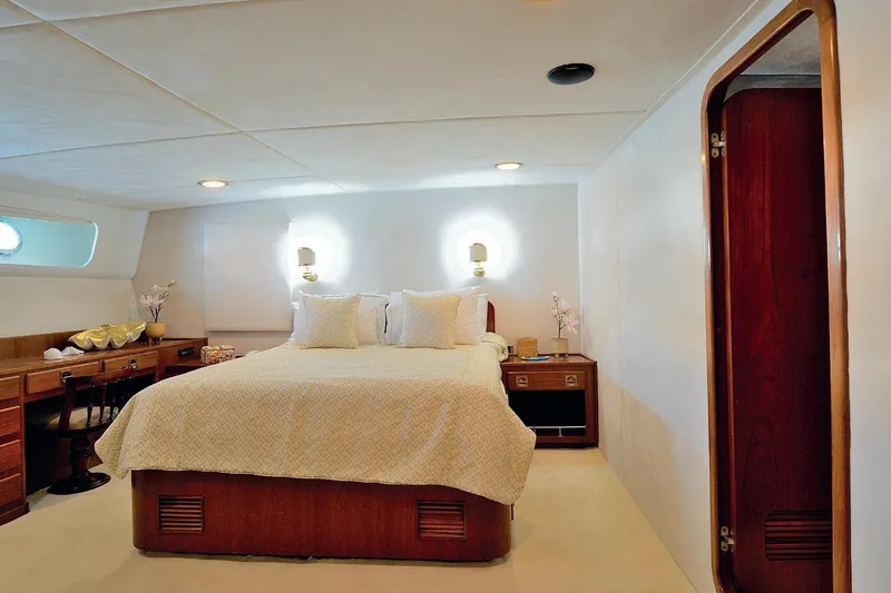 Madame Thelma Yacht Photos Pics Luxurious bedroom interior on 1975 CRN Ancona Navetta 40 yacht, featuring elegant wood furnishings.