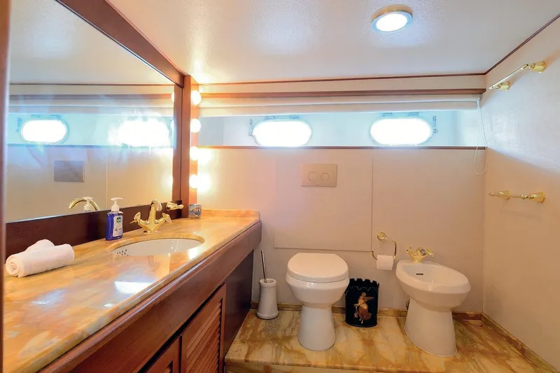Madame Thelma Yacht Photos Pics Luxurious bathroom on 1975 CRN Ancona Navetta 40 yacht with marble countertop and gold fixtures.