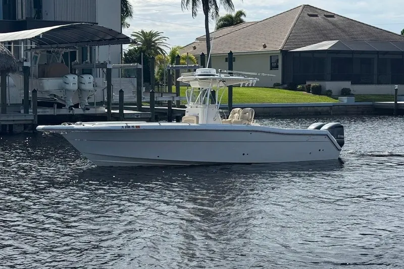  Yacht Photos Pics 2014 Stamas 317 Tarpon boat on calm water near a dockside home.