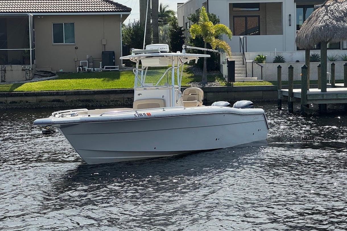 2014 Stamas 317 Tarpon boat on water near residential dock.