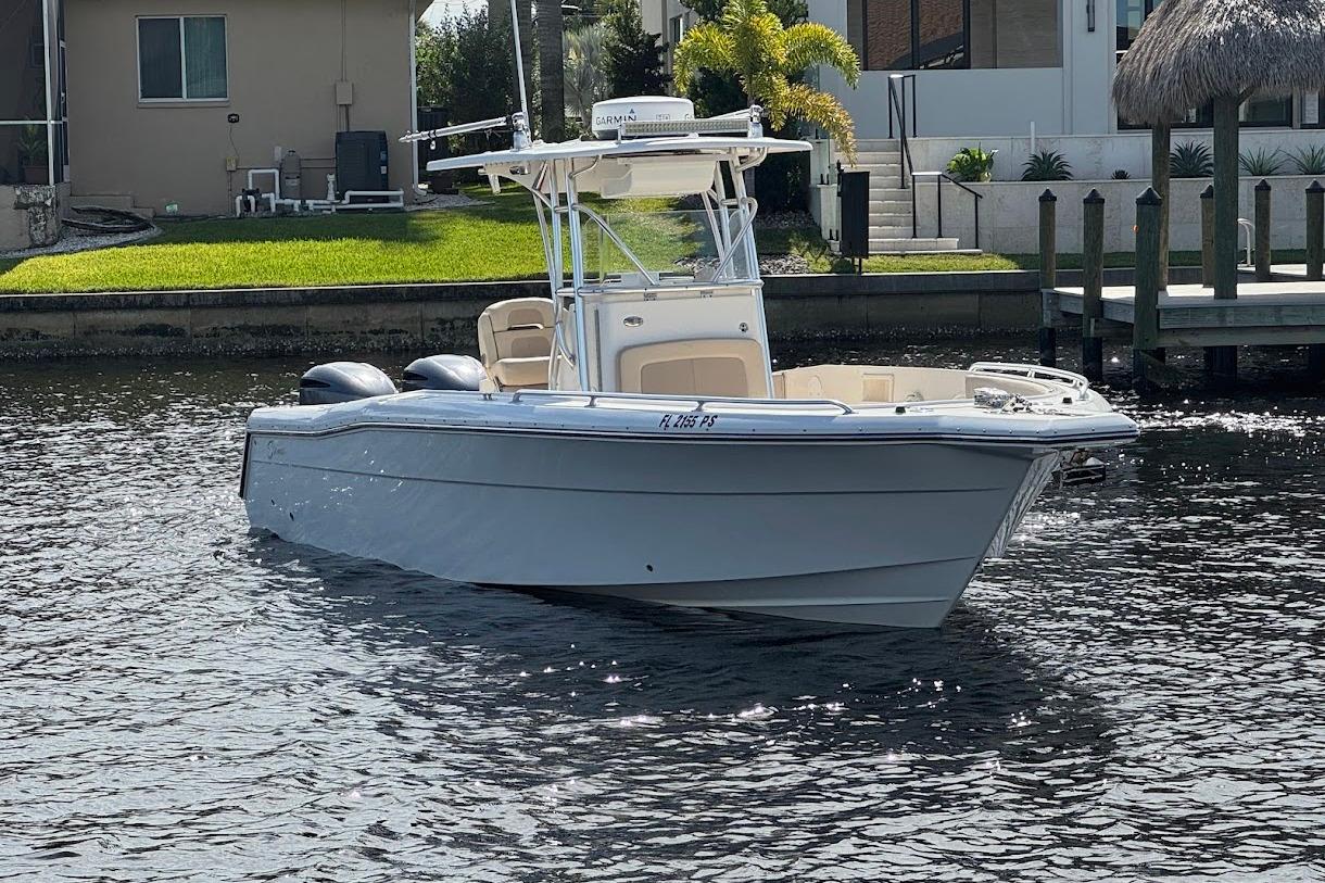 2014 Stamas 317 Tarpon boat on a calm waterway near residential docks.