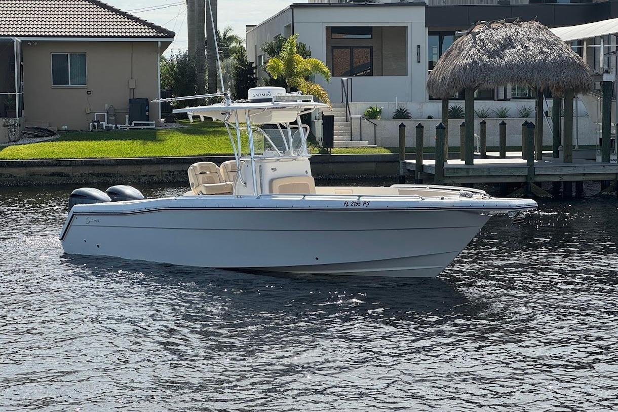 2014 Stamas 317 Tarpon boat docked on a sunny waterfront.