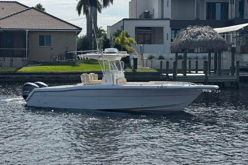  Yacht Photos Pics 2014 Stamas 317 Tarpon boat on a calm waterfront, with modern houses in the background.