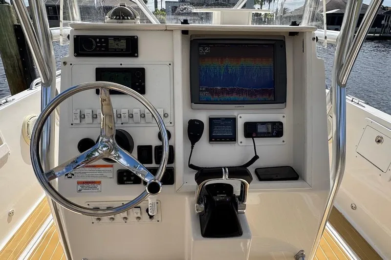  Yacht Photos Pics 2014 Stamas 317 Tarpon boat dashboard with steering wheel and navigation equipment.